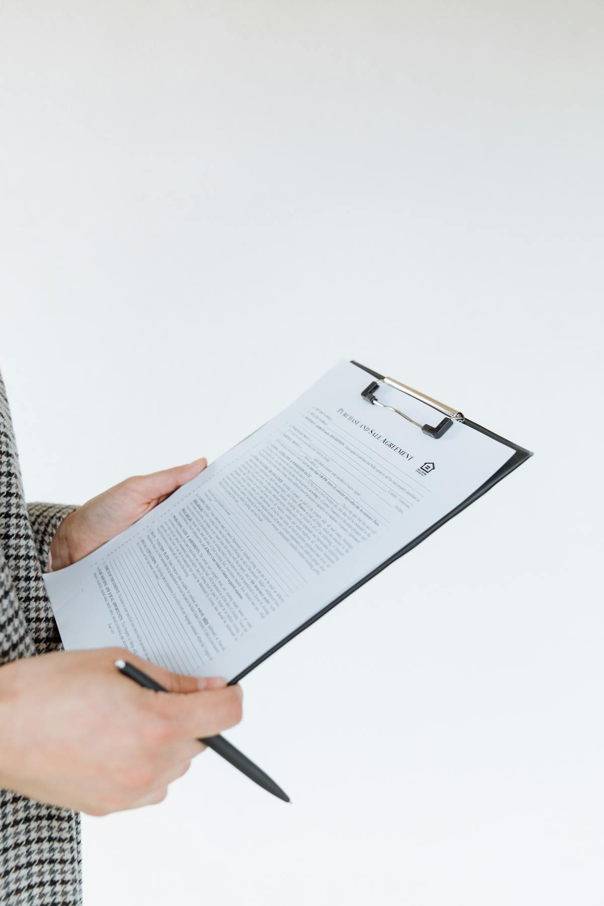 Professional holding filled assessment form on clipboard with pen